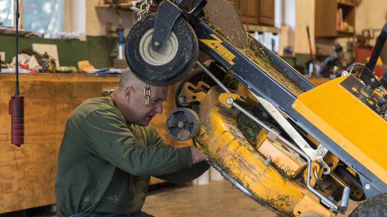 A man working on his lawn mower