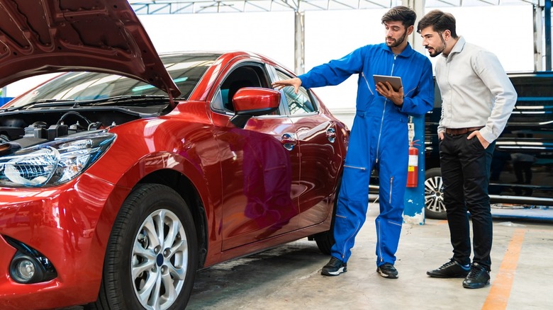 repair tech talking to customer about car