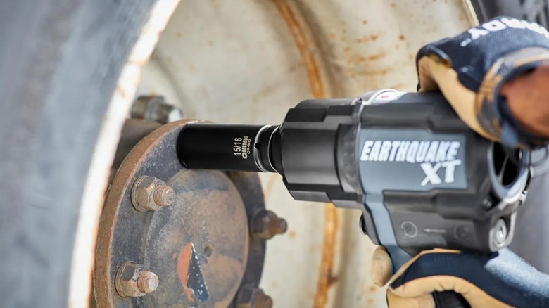 a person using an impact wrench with a quinn socket to remove lug nuts