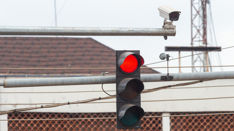 Red traffic signal with overhead camera mounted on its own pole