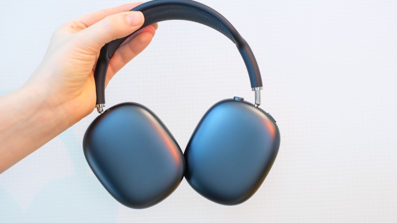 Person holding a pair of AirPods Max headphones