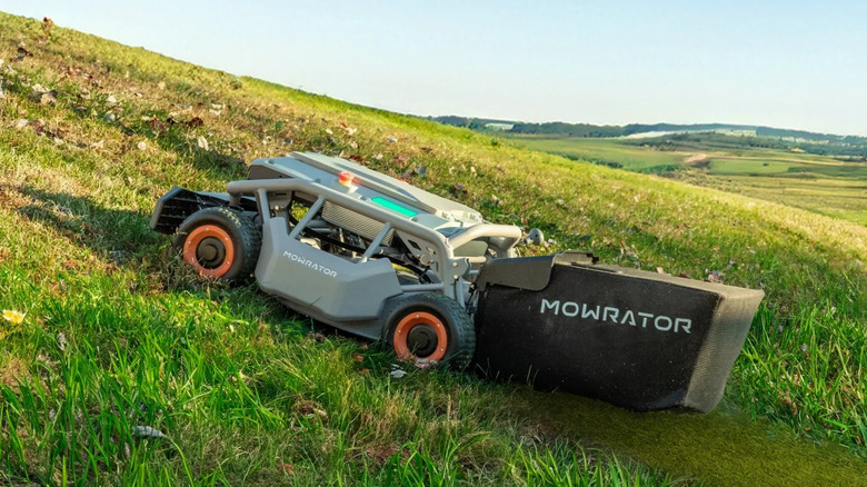 a remote-controled Mowrator lawn mower triming grass on a slope
