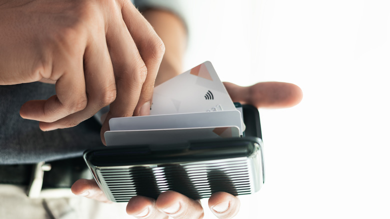 Person pulling a card out of an RFID-protected wallet