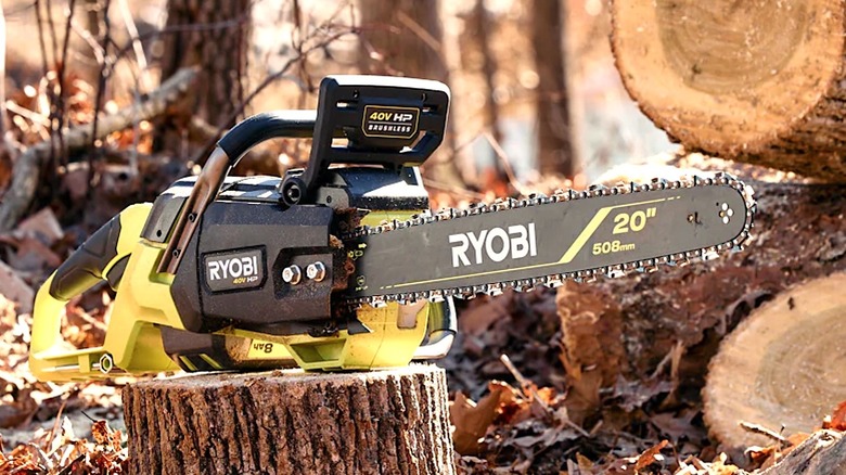 Ryobi chainsaw sitting on top of a log stump