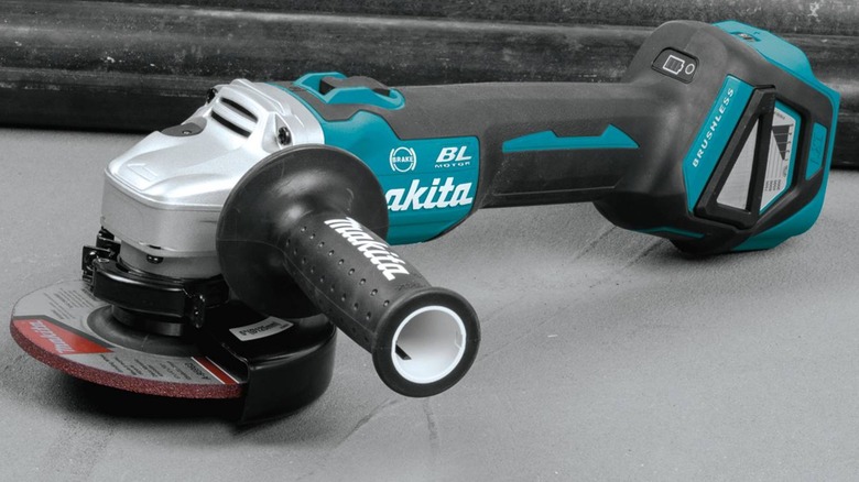 A Makita LXT angle grinder on the floor.