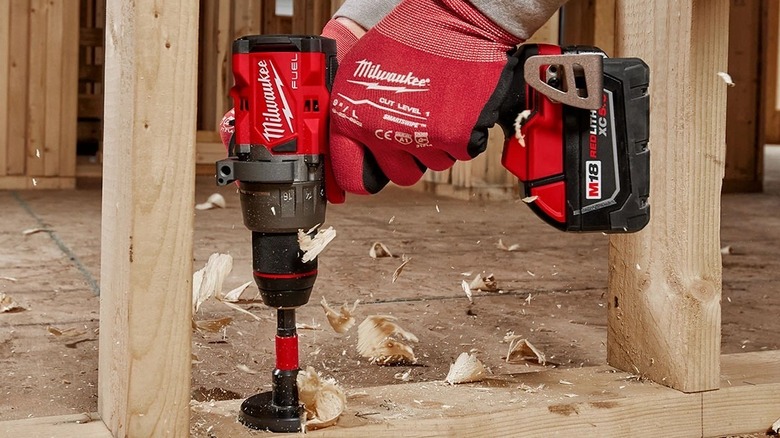 Person using a Milwaukee wood drilling tool