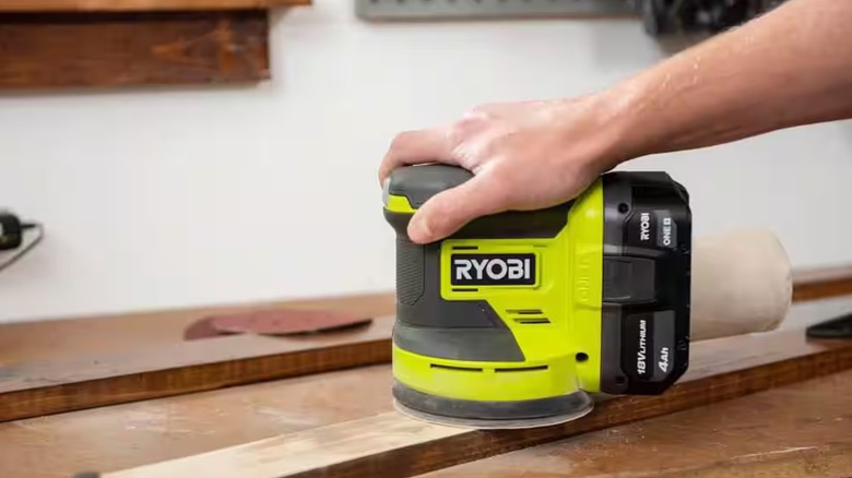 Person holding the Ryobi Random Orbit sander