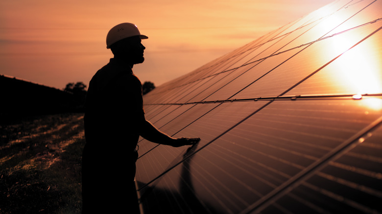 person's silhouette with solar panels