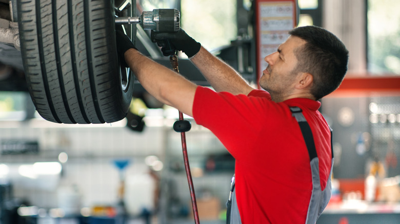 Tire installer using impact wrench to attach wheel to vehicle