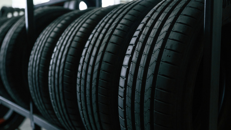 Tires aligned on a storage rack.