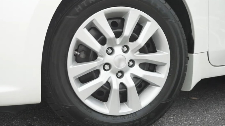 A Sumitomo tire on a white car.