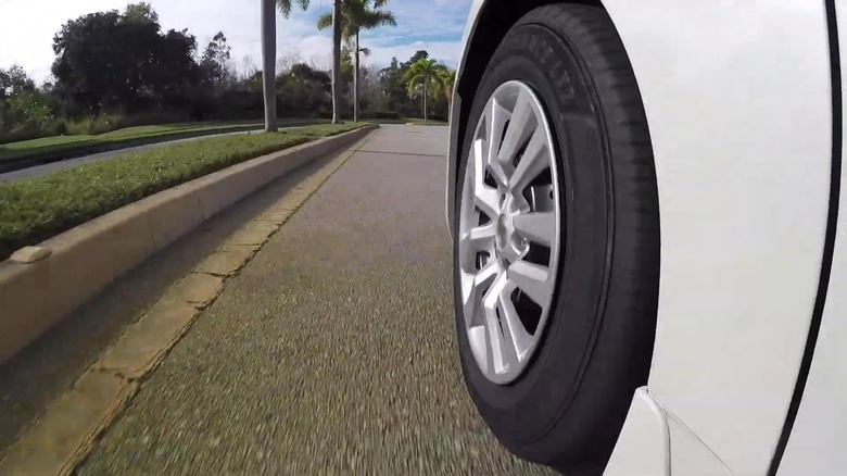 A Sumitomo tire on a white car.
