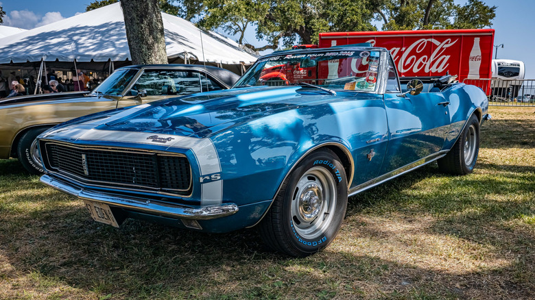 A blue 1967 Chevrolet Camaro at an open air car show, front 3/4 view