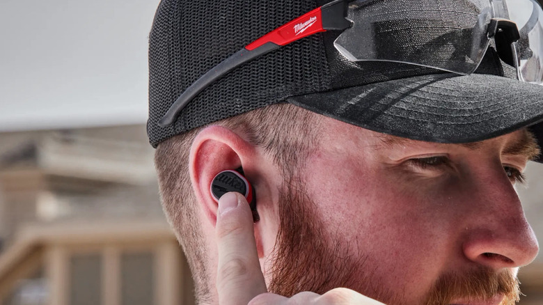 man wearing Milwaukee earbuds