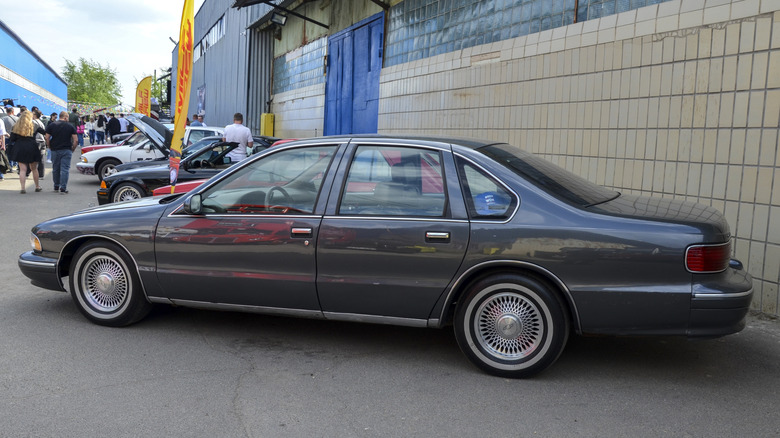 Side view of gray 1990s Chevrolet Caprice sedan at car show.