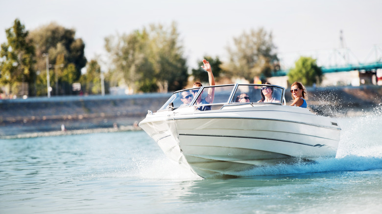 A group of people on a speedboat cruising through a waterway.