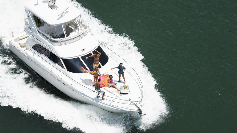 A group of people partying on a motorboat moving through water.