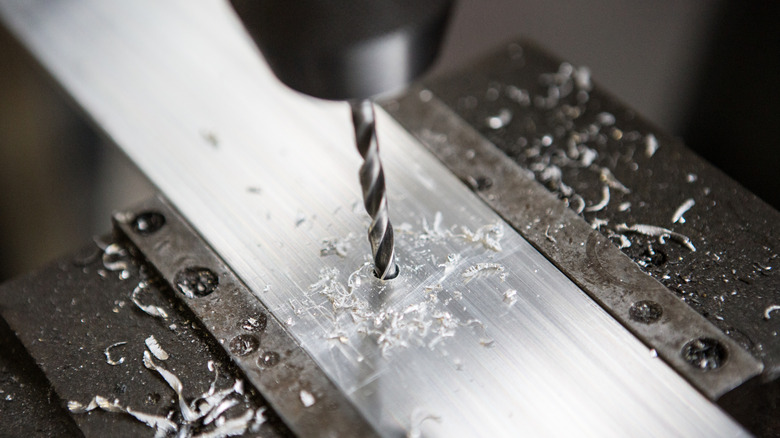 Using a power drill to drill into a metal surface