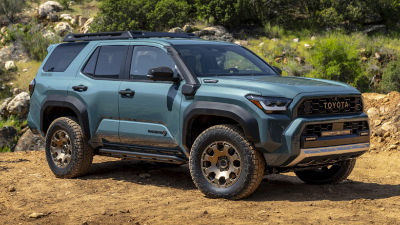 2025 Toyota 4Runner Trailhunter parked off-road with rocks and trees in the background