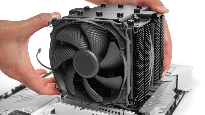 A person is installing a CPU air cooler inside a computer