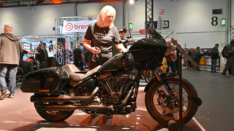 Woman with a black shirt, checking out a new Harley-Davidson motorcycle