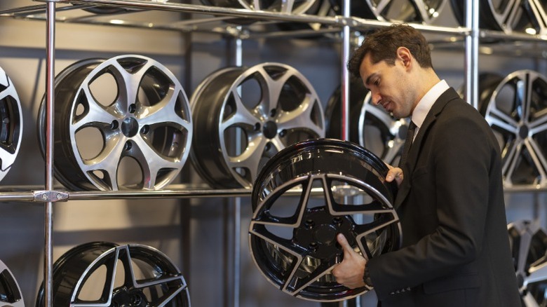A person holding and inspecting a car rim