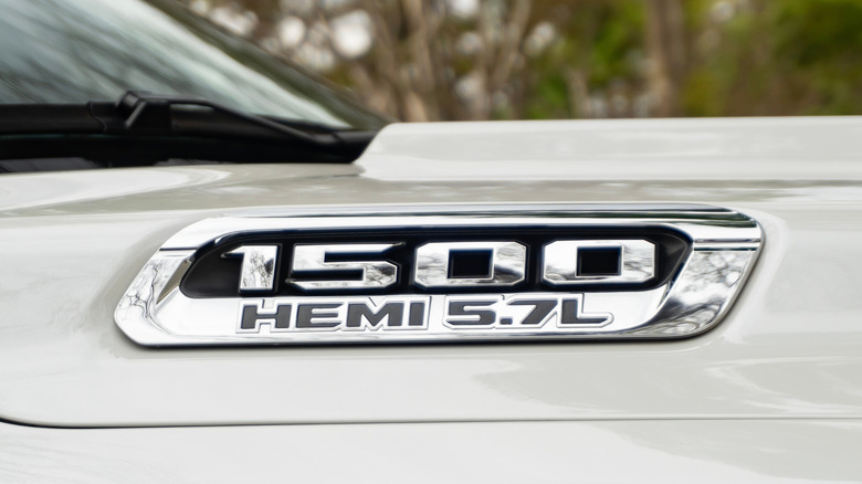 Close up view of RAM 1500 Hemi 5.7L badge on white fender.