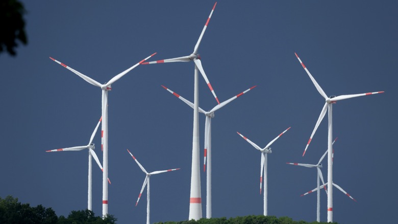 Multiple wind turbines against a dark sky