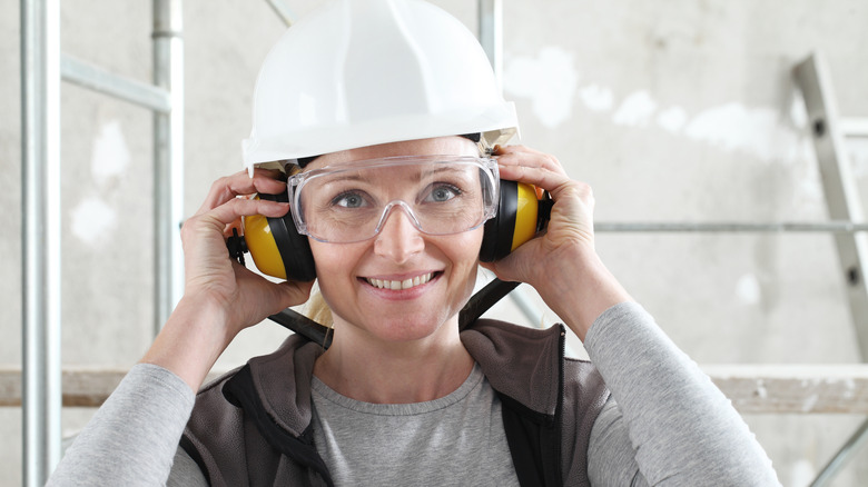 A Woman Wearing Safety Equipment To Protect Her Eyes And Ears