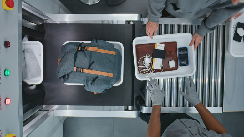 Looking down on a TSA checkpoint with electronic devices in a tray