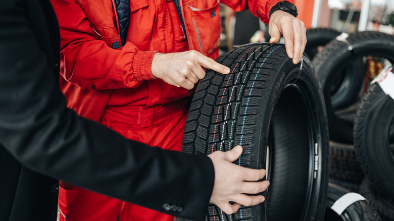 Two people inspecting car tire
