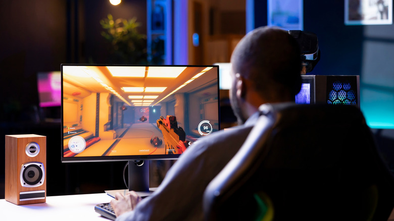 A man playing an FPP game on his computer.