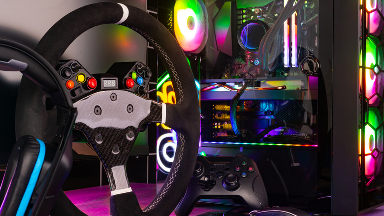 RGB-colored CPU along with a racing wheel and a controller that have different-colored buttons embedded on them.