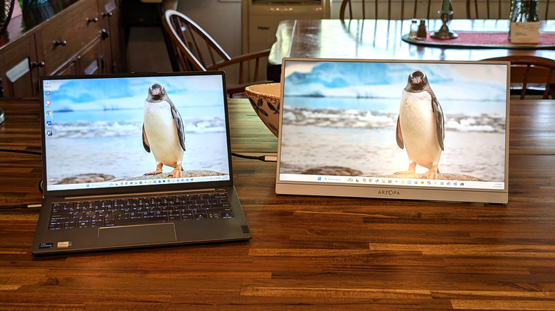 Arzopa Z1FC Grey Portable Monitor on a wooden table connected to a laptop with a penguin picture for the desktop