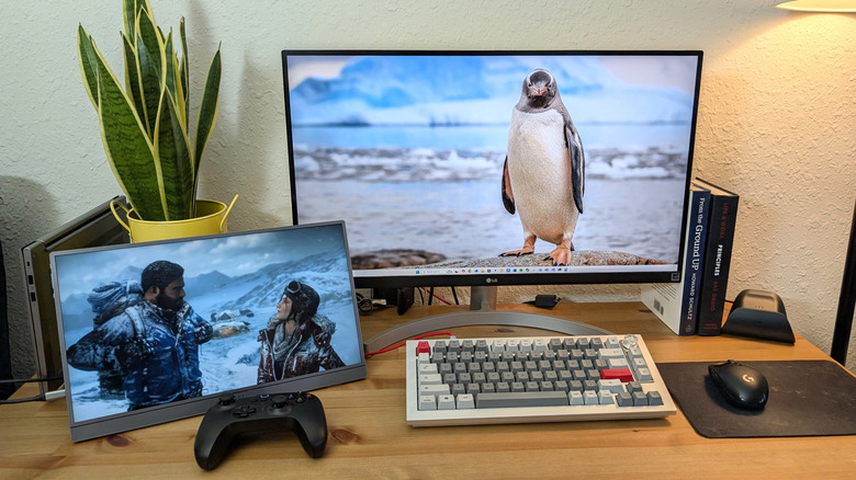 Arzopa Z1FC Grey Portable Monitor on a desk with a Xbox controller in front of it displaying a scene from Tomb Raider next to silver keyboard.