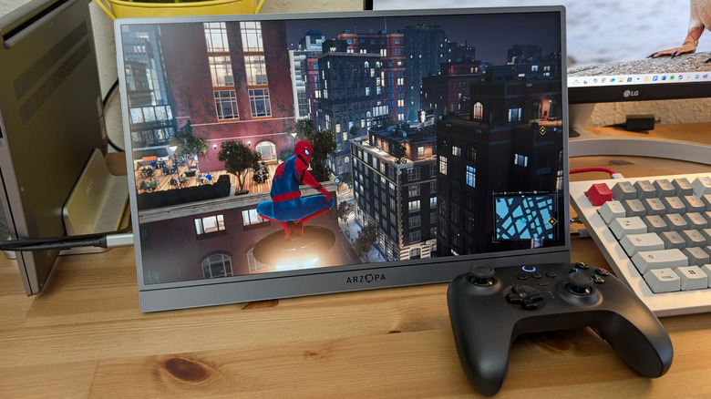 Arzopa Z1FC Grey Portable Monitor displaying a scene from "Spider-Man Remastered" with an Xbox controller in front