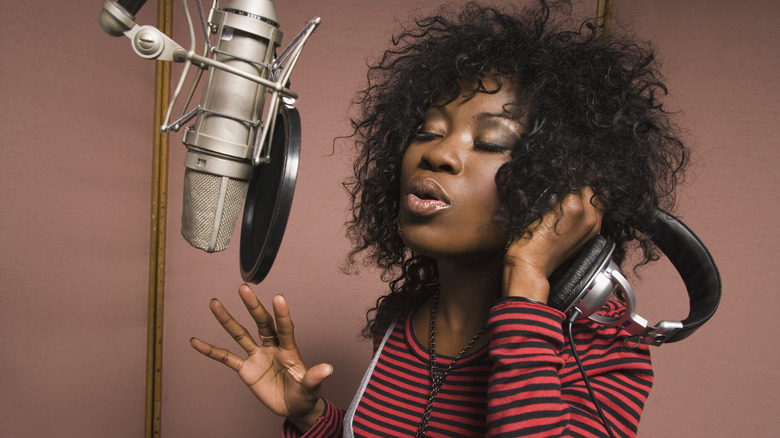 Singer records vocals with studio microphone