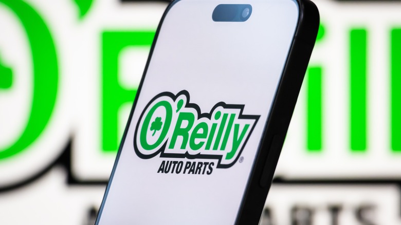 O'Reilly logo on smartphone in front of O'Reilly sign