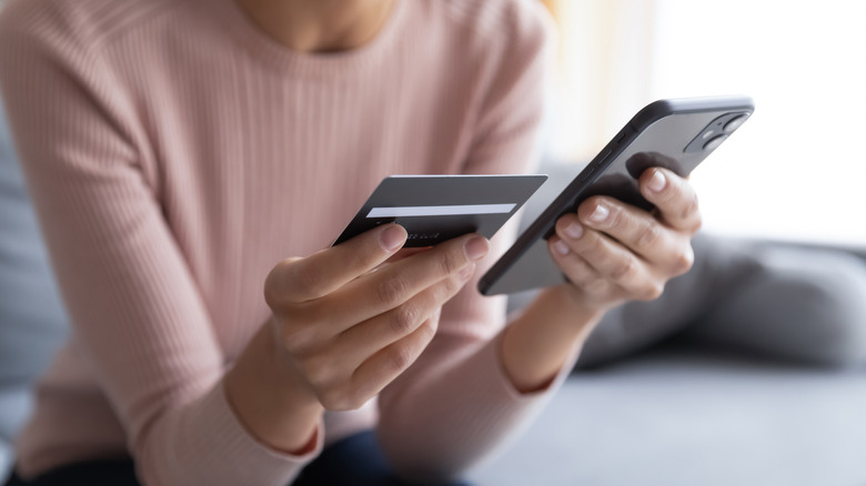 Someone holding phone and credit card