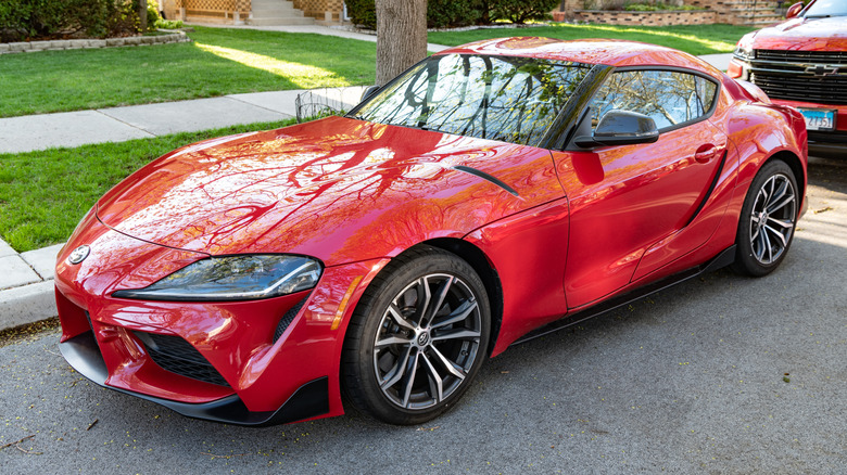 A red 2-liter Toyota Supra parked on a street.