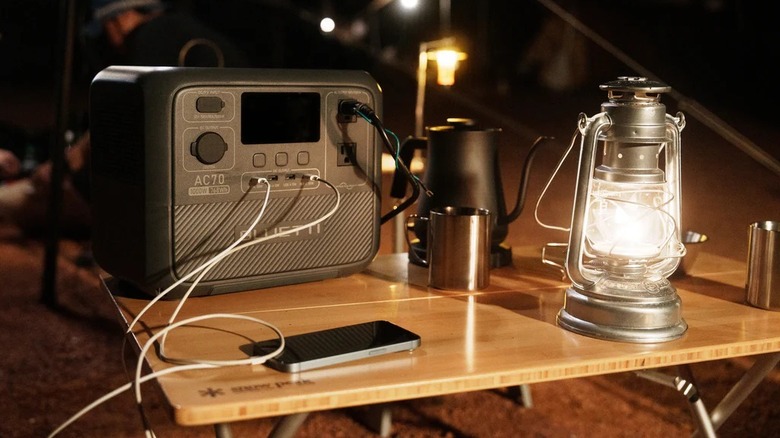 Bluetti battery generator on a table connected to multiple devices