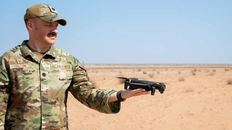 U.S. Air Force member holds a small drone.