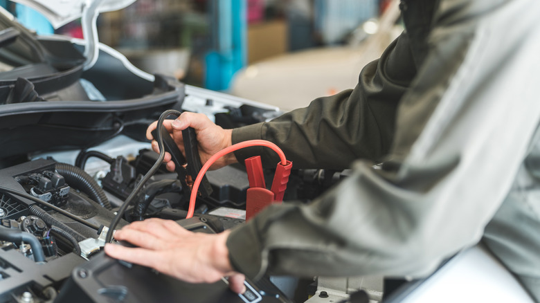 mechanic jumps starting a car