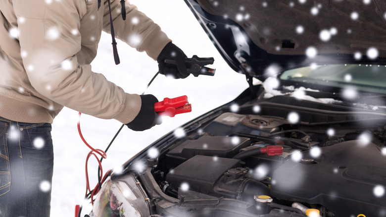 Person using jumper cables on a car battery