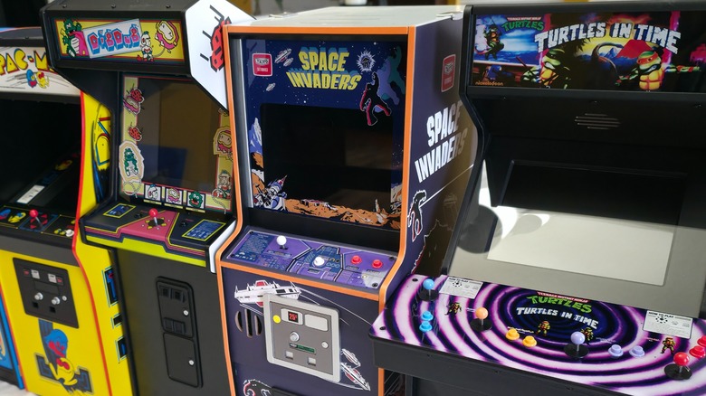 Pac-Man, Dig Dug, Space Invaders, and Teenage Mutant Ninja Turtles: Turtles in Time from Quarter Arcades arranged in a row