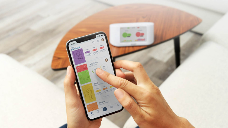 AirVisual app on iPhone with air quality monitor in the background