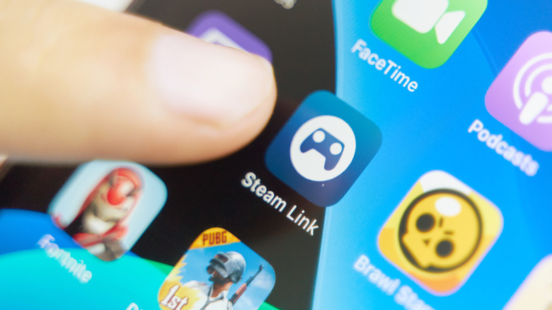 person pointing to steam link app on iphone