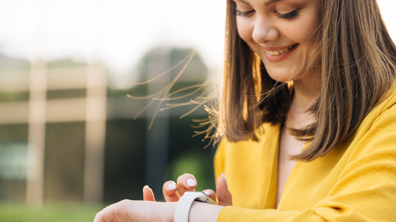 woman smiling, using her Apple Watch