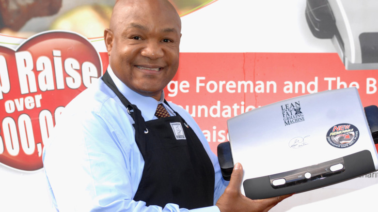 George Foreman at an event holding plates of food