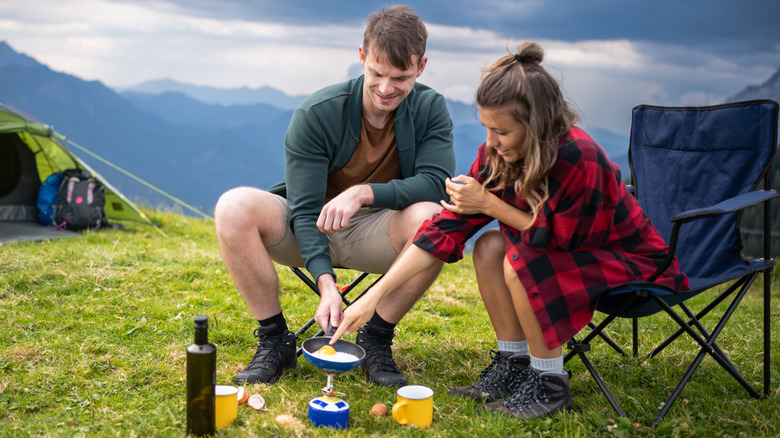 camping couple cooking meal